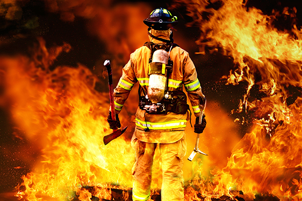 Bild: Feuerwehrmann vor tobender Feuerwand Bild: Feuerwehrmann vor tobender Feuerwand