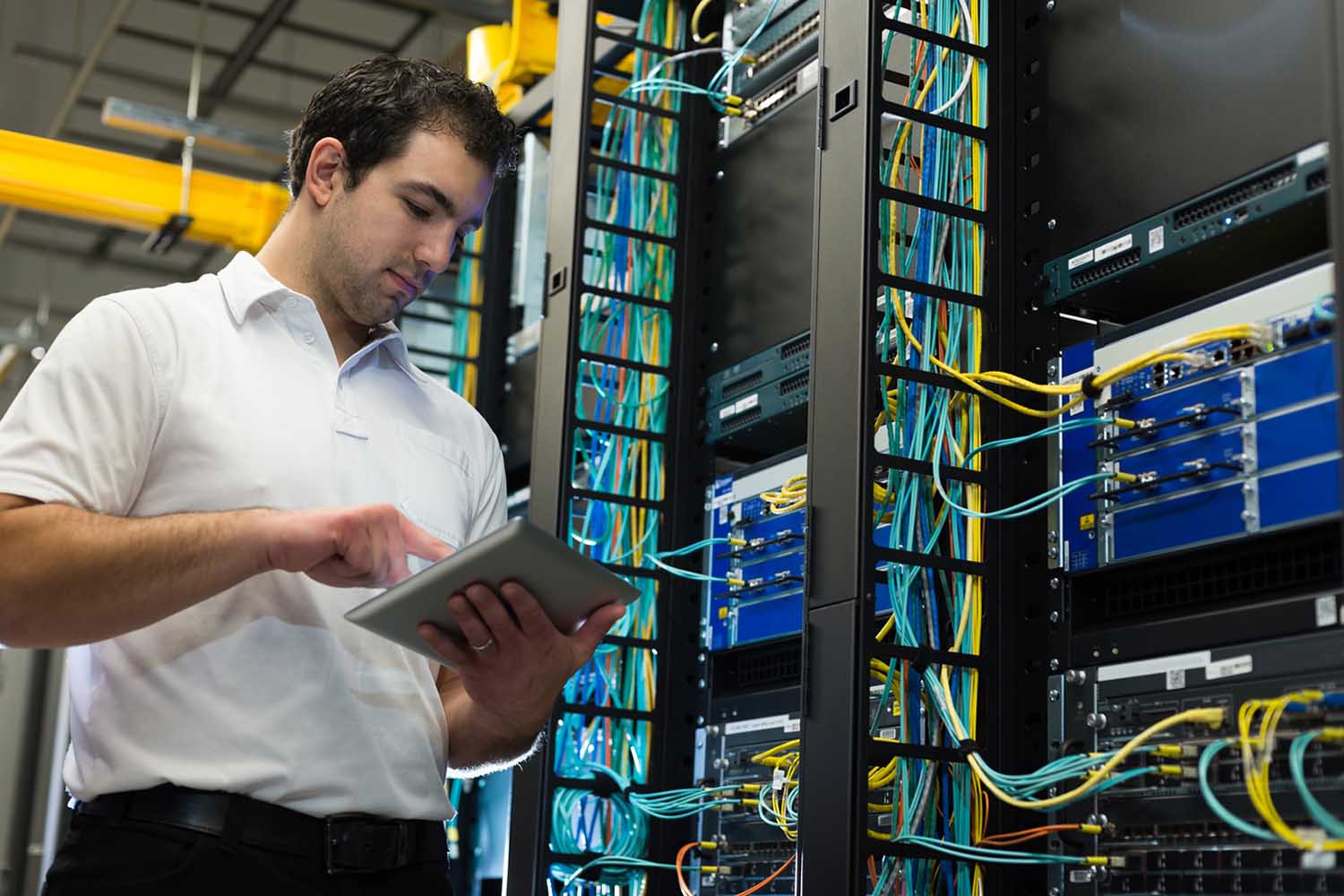 Image: man standing in a server room Image: man standing in a server room
