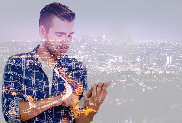 Bild: Mann mit Tablet vor Stadt, CONET Office 365 für Unternehmen, Office 365 Updates