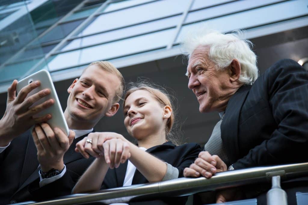 Bild: Gemischtes Team betrachtet Smartphone