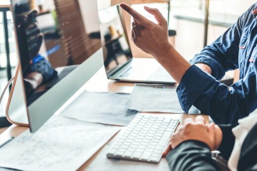 Foto: Softwareentwickler zeigt Code auf Bildschirm