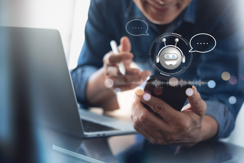 Photo: Contact Center Solutions Chatbot symbol in front of smartphone and notebook