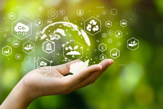 Foto: Nachhaltigkeit - offene Hand hält Nachhaltigkeitssymbole vor gruenem Hintergrund