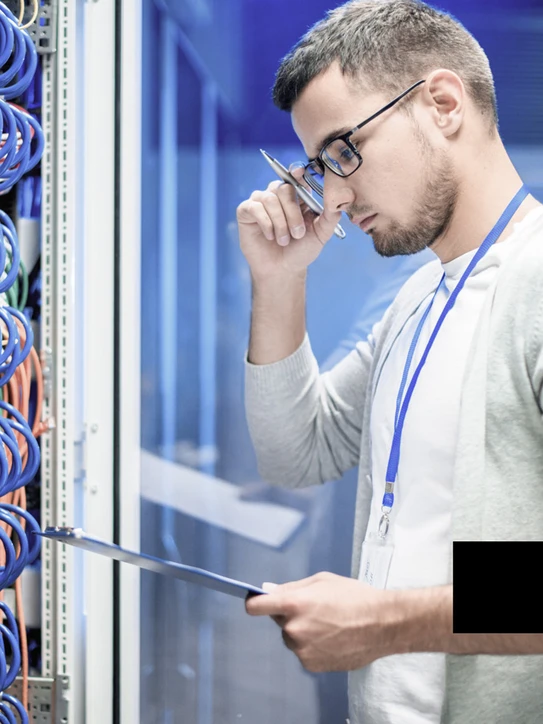 Foto: Mann mit Tablet vor Server-Schrank