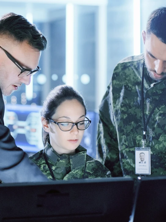 Foto: Personen in Militäruniform schauen auf PC-Monitore