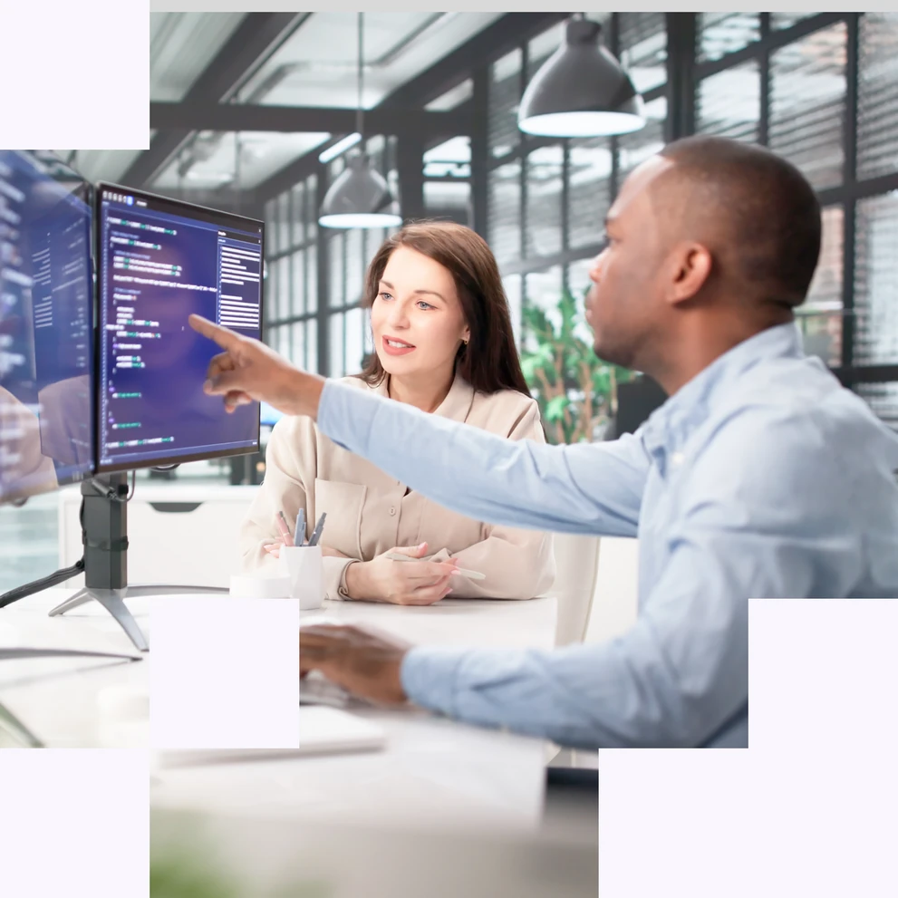 Zwei Personen analysieren gemeinsam Daten und Code auf einem Bildschirm in einer modernen Arbeitsumgebung