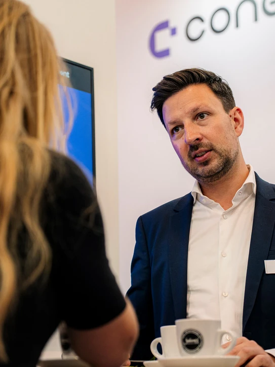 Foto: Zwei Personen im Gespräch am Messestand der E-world 2026