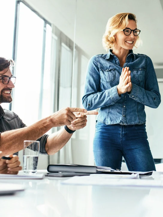 Foto: Frau steht vor sitzenden Mitarbeitenden