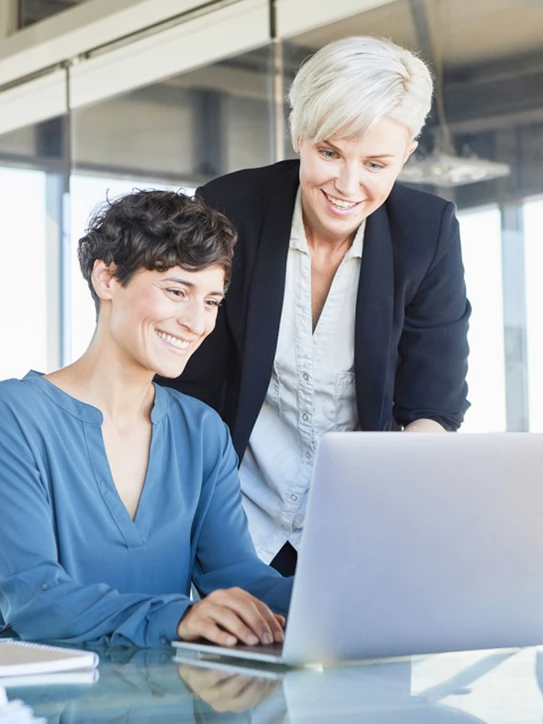 Foto: Zwei Kolleginnen schauen gemeinsam auf ein Notebook