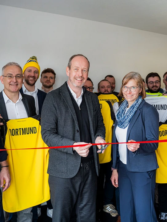 Foto: Mitarbeitende und conet CEO Martin Wibbe durchschneiden Band zur Eröffnung