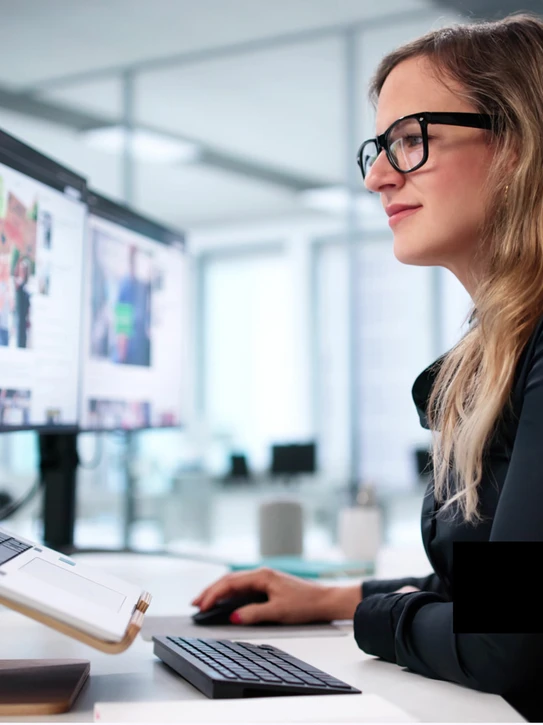 Foto: Frau sitzt vor Notebook in Büroumgebung